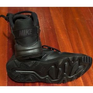 Men Black Nike Tennis Shoe in a size 11.5. With rubber sole and the Nike logo.